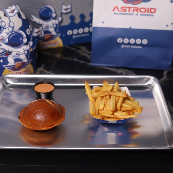 Astroid Burgers And Wings meal with a burger bun, fries, and dipping sauce on a tray.